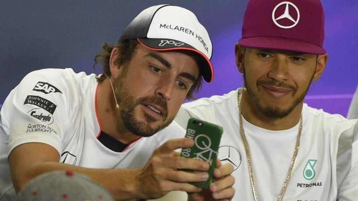 Alonso toma una fotografía con su móvil junto a Hamilton en Montmeló.