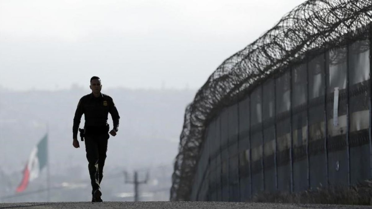 Un agente patrulla la valla que separa México y San Diego.