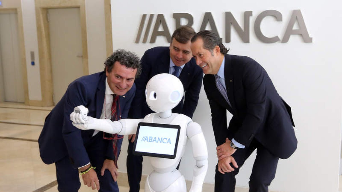 Un robot hace un ‘selfie’ al vicepresidente y al consejero delegado de Abanca (derecha). RAQUEL P. VIECO