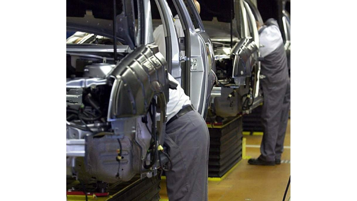 Trabajadores ensamblan piezas de coches en una fábrica. A. DEDERT