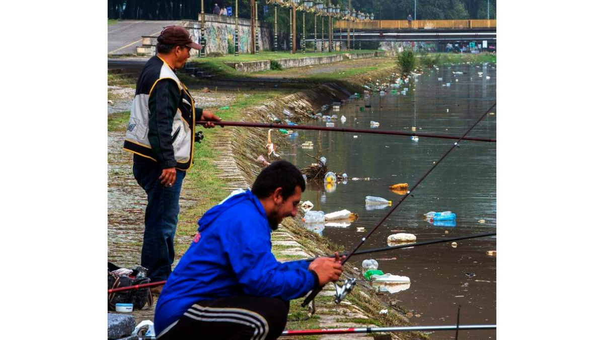 Ds hombres pescan en el río Vardar, cubierto de botellas y basura. GEORGI LICOVSKI