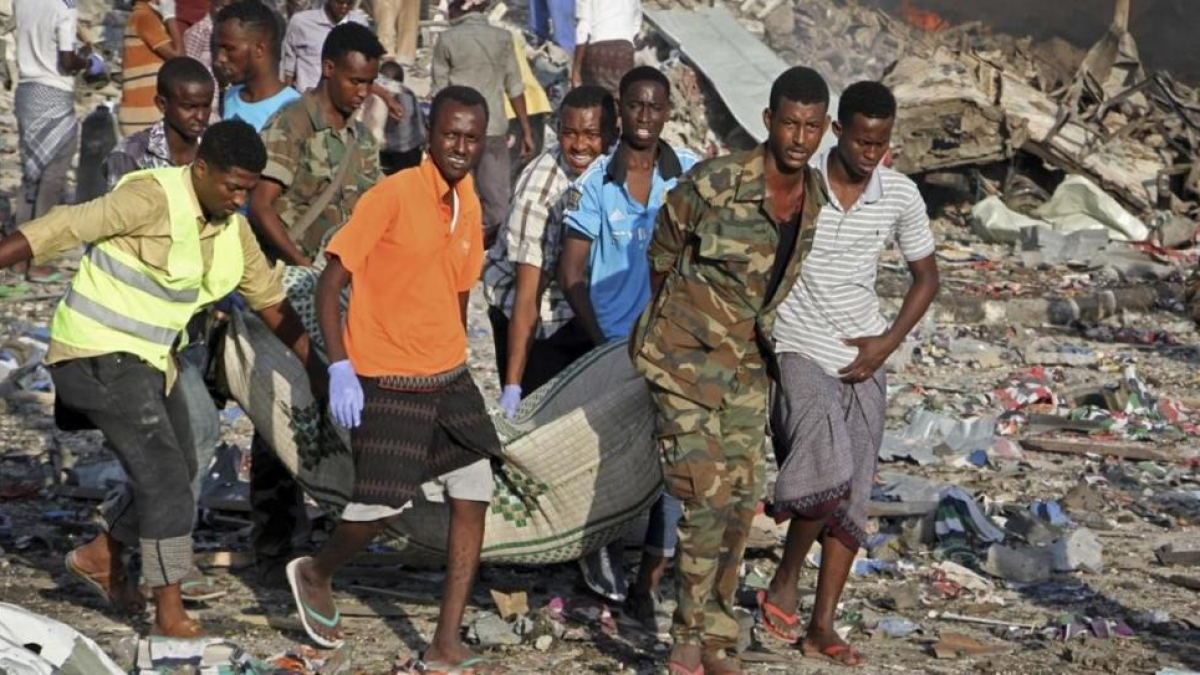 Traslado de un cadáver del lugar donde se ha producido uno de los atentados con bomba en Mogadiscio.