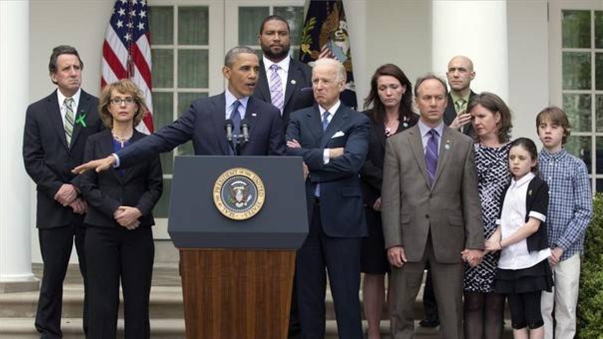 Obama comparece acompañado de la excongresista Gabby Giffords (segunda por la izquierda), el vicepresidente Joe Biden (quinto) y familiares de las víctimas de Newtown.