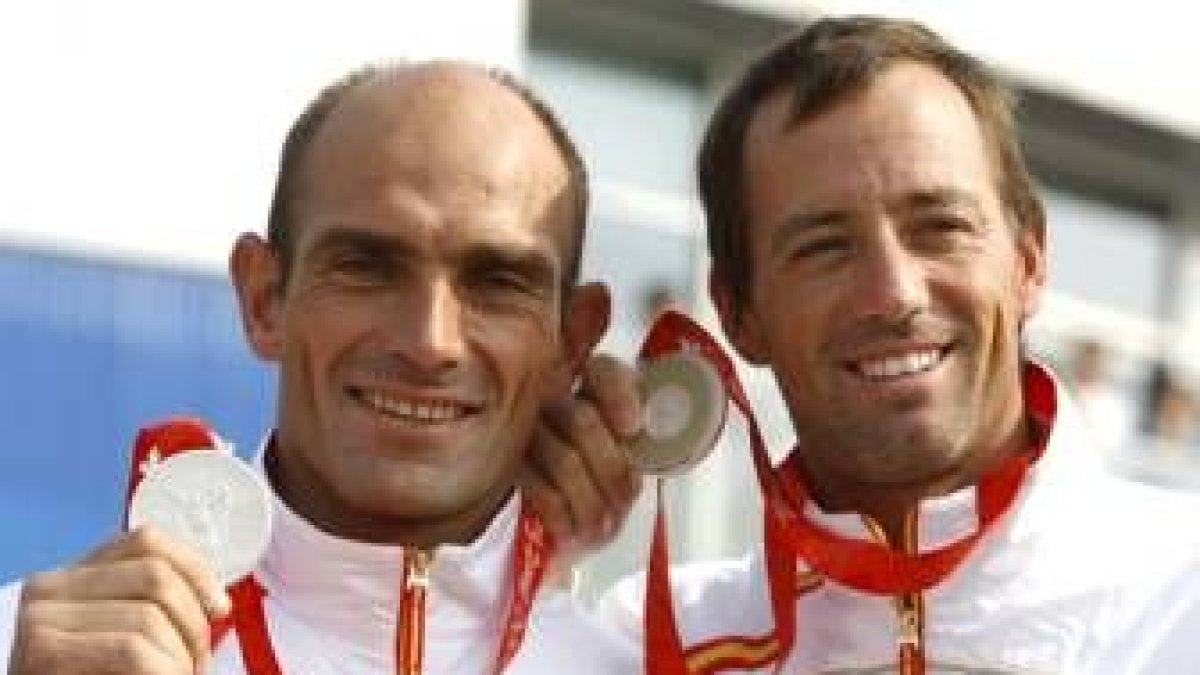 Los regatistas españoles Iker Martínez (d) y Xabier Fernández muestran la medalla de plata