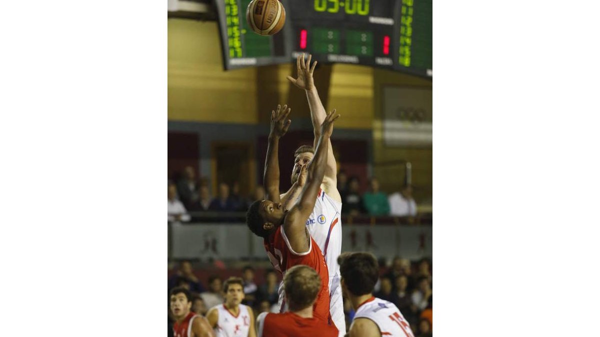 Thomas intenta lanzar a canasta ante la defensa de Phillips.