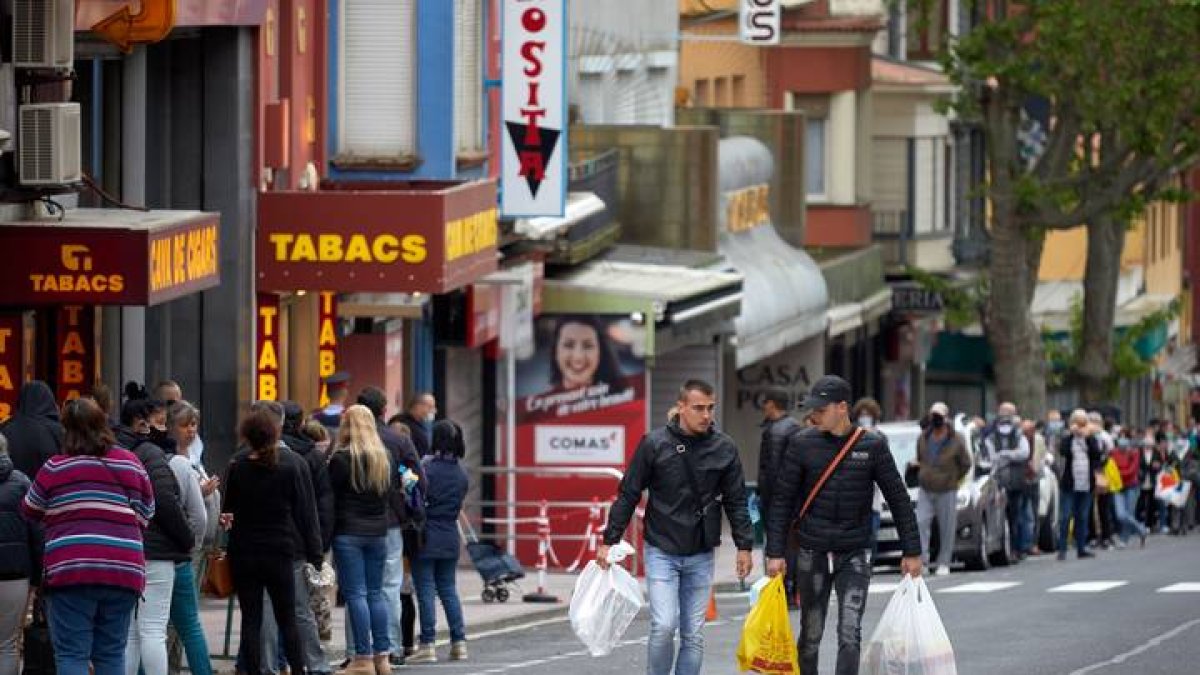Colas de ciudadanos franceses, este martes en el núcleo fronterizo del Pertús, siempre en la acera que pertenece a España. DAVID BORRAT