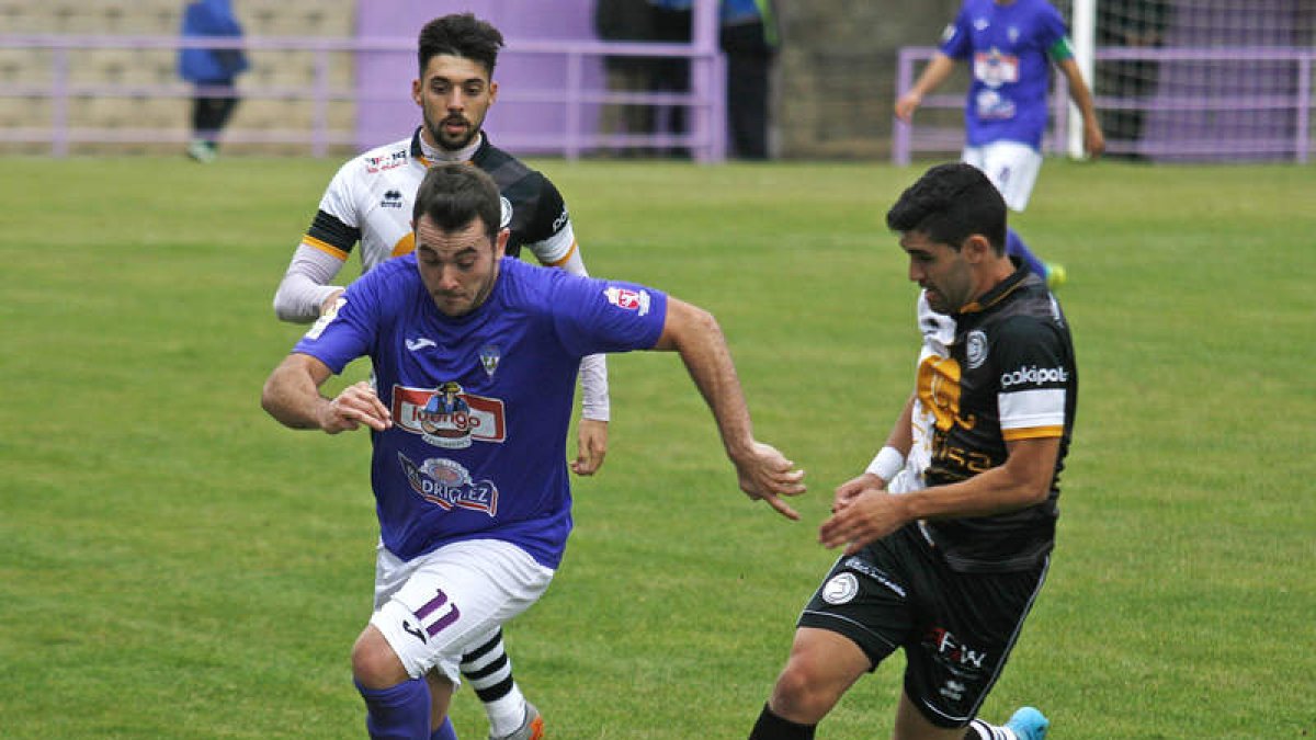 Álex Matos se lleva el balón a pesar de la oposición de dos jugadores salmantinos. F. OTERO PERANDONES
