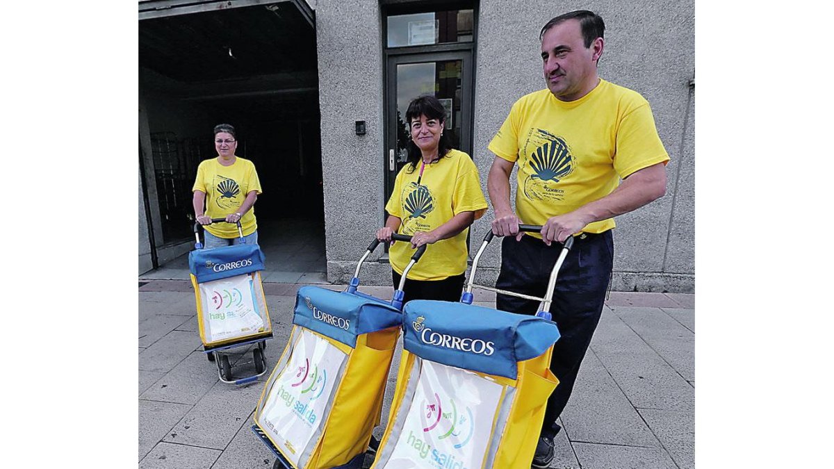 Tres carteros de Ponferrada con camisetas del Camino.