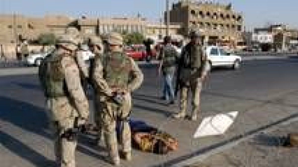 Soldados estadounidenses contemplan el cuerpo de un iraquí que pretendía huir de Bagdad