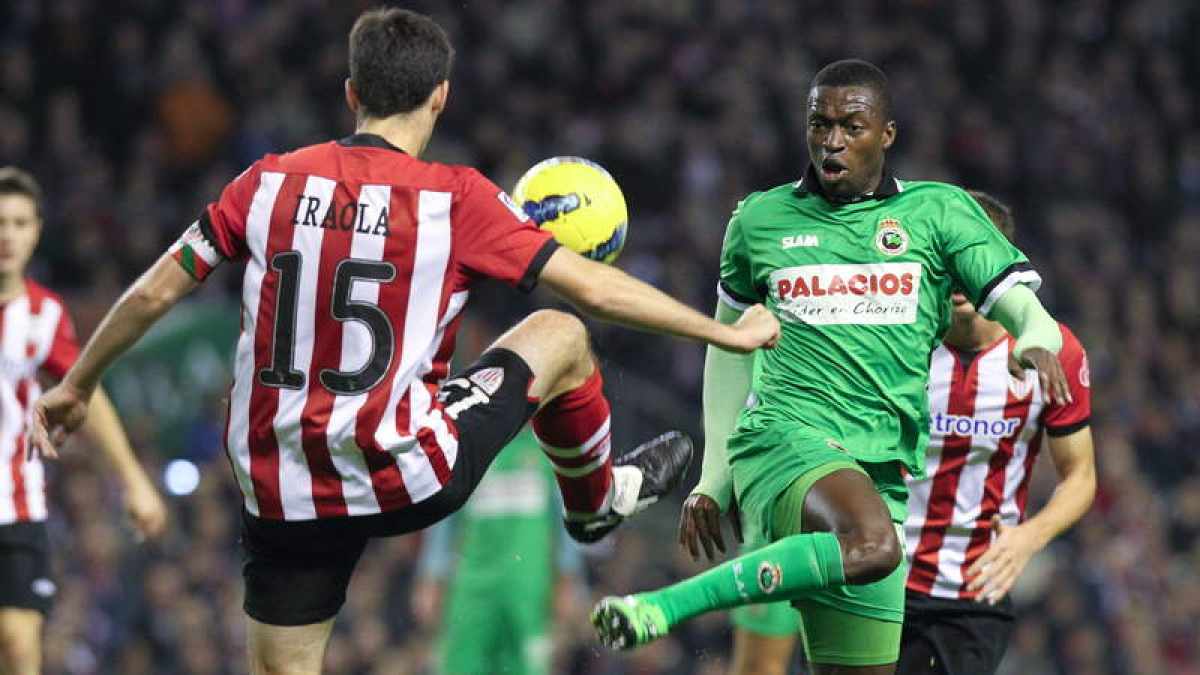 El defensa del Athletic de Bilbao, Iraola, disputa un balón al senegalés del Racing, Diop.
