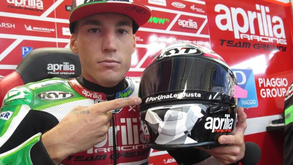 Aleix Espargaró muestra, hoy, en Austria, la inscripción que luce en su casco. /