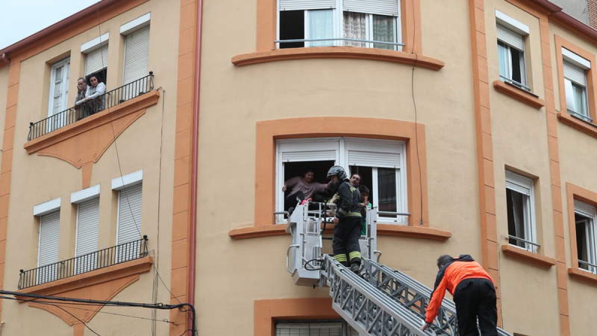 Los bomberos rescatan a una de las familias en el segundo piso del inmueble utilizando el camión autoescala. ANA F. BARREDO
