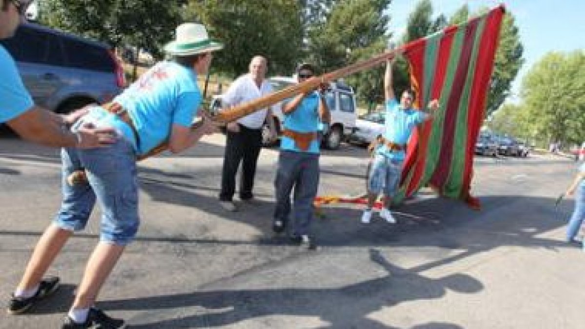 Uno de los grupos participantes en el desfile de pendones, en pleno esfuerzo por erguir la vara.