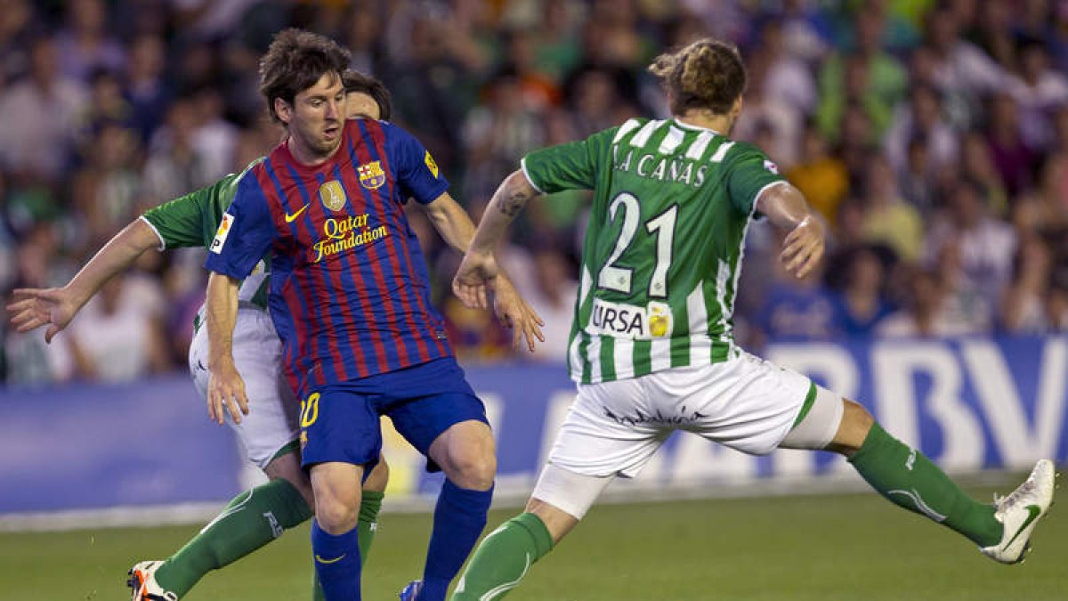 Messi conduce el balón entre Cañas y Beñat.