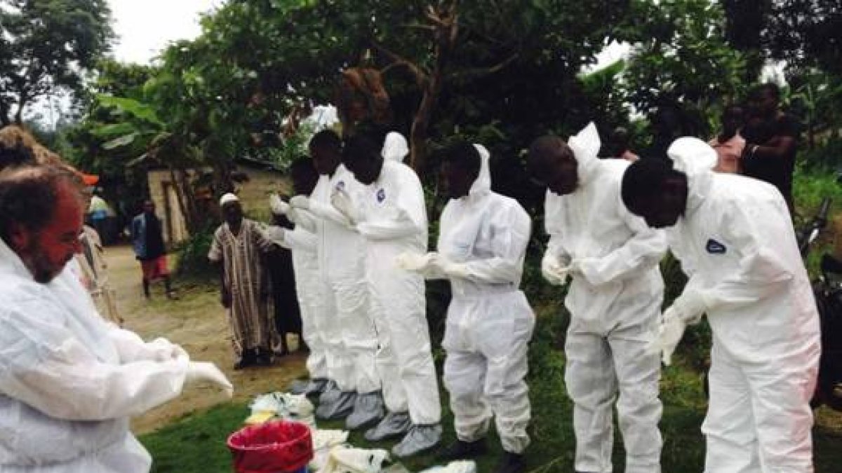 Voluntarios preparándose para ponerse los monos de aislamiento para tratar con enfermos de ébola, en Sierra Leona.
