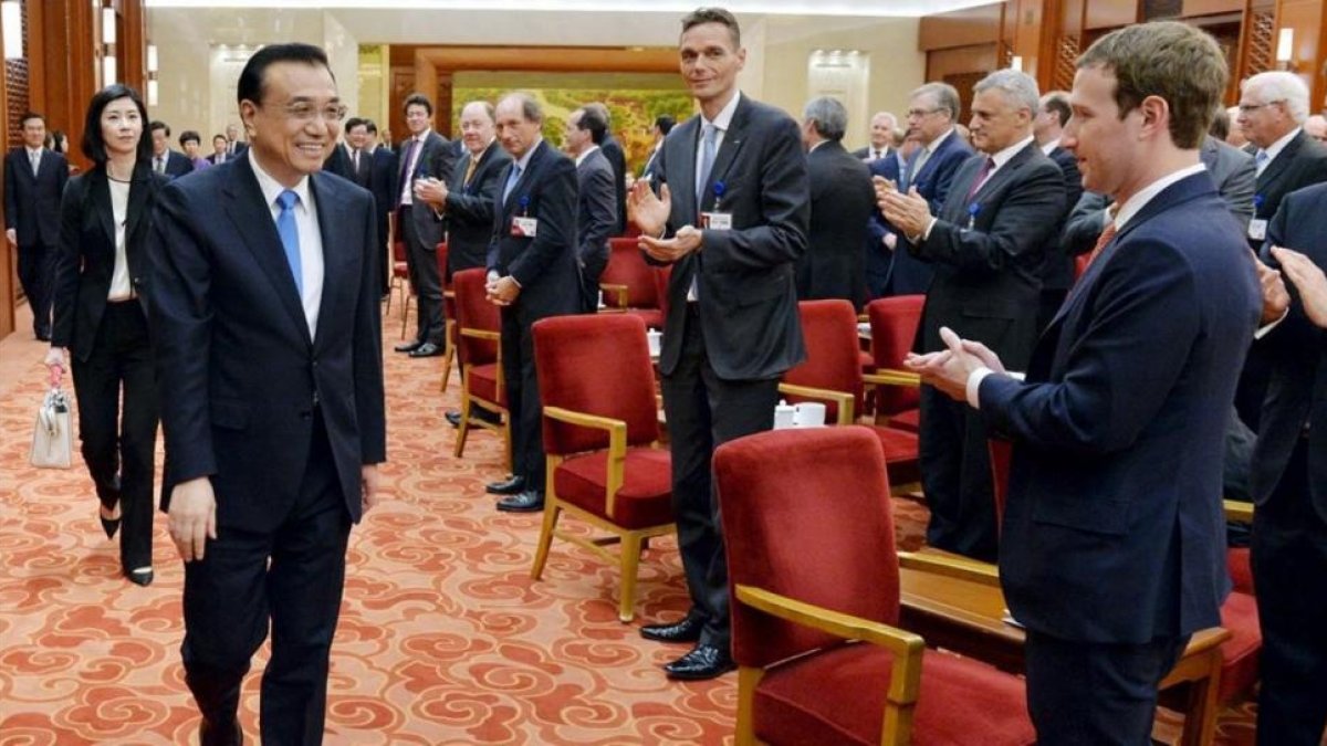 Zuckerberg (derecha) aplaude a la llegada del primer ministro chino, Li Keqiang, en una reunión empresarial en Pekín, el 21 de marzo.