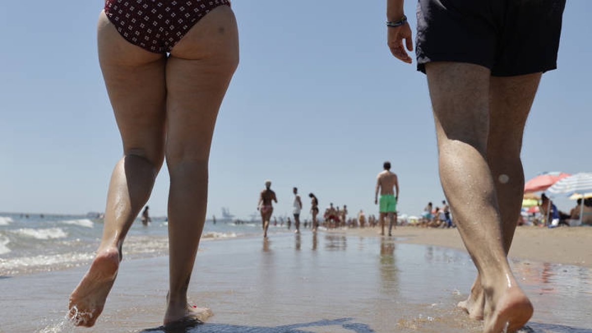 Una pareja pasea este sábado en la orilla de la playa de La Patacona de Alboraya, localidad junto a la ciudad de Valencia, MANUEL BRUQUE