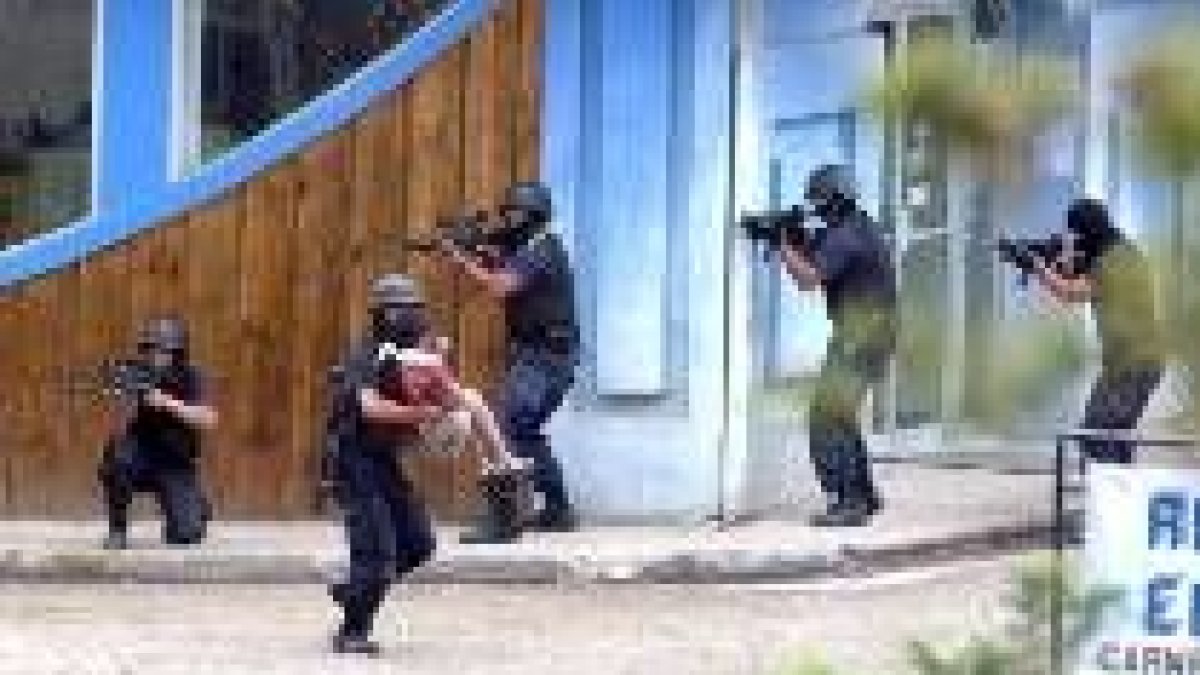 Un policía evacúa a una rehén durante el asalto a una entidad bancaria en Monteverde, Costa Rica