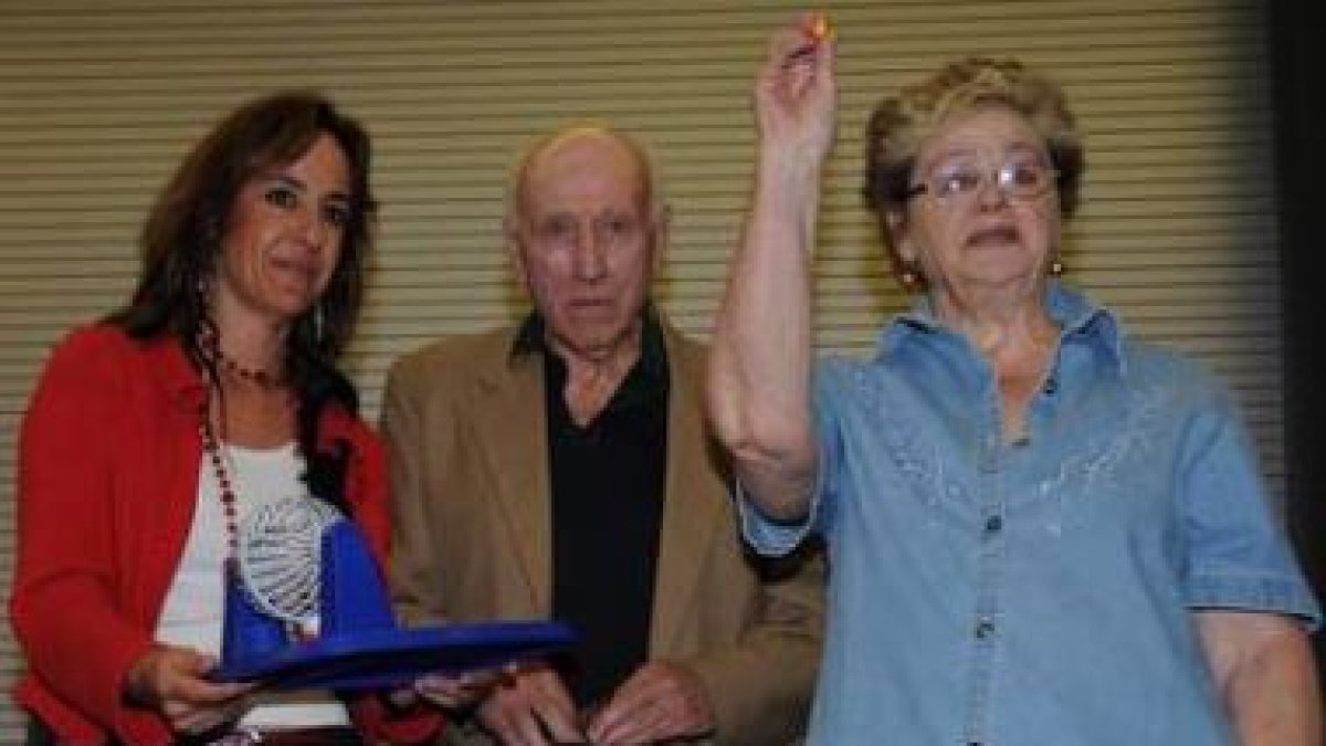 Una mujer muestra una de las bolas del sorteo, en presencia de Catalina Díaz.