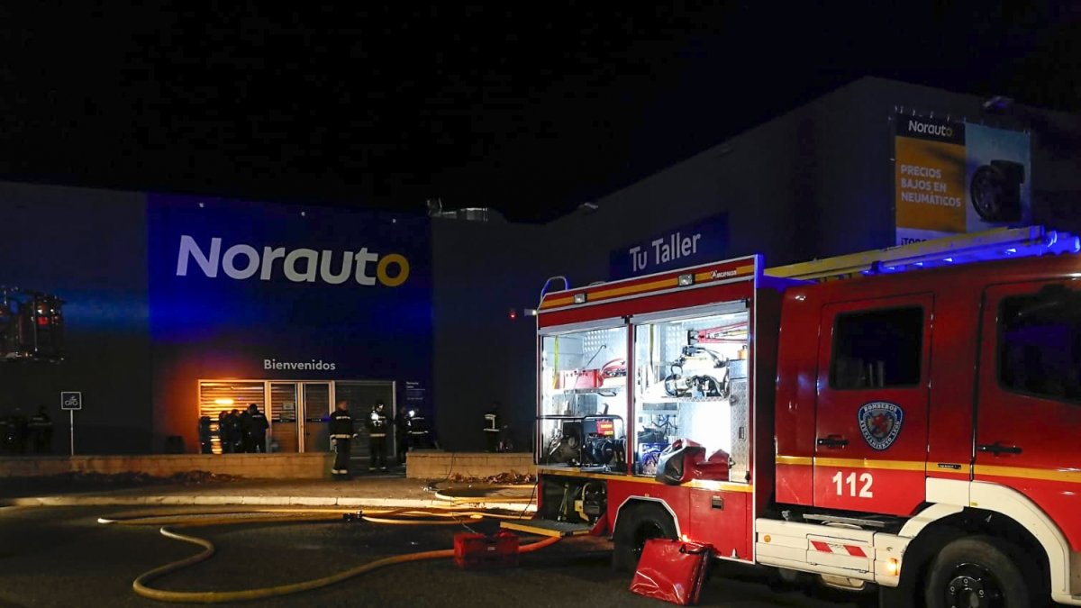Un vehículo de los bomberos junto a la nave de Norauto que se incendió ayer. LUIS CANAL