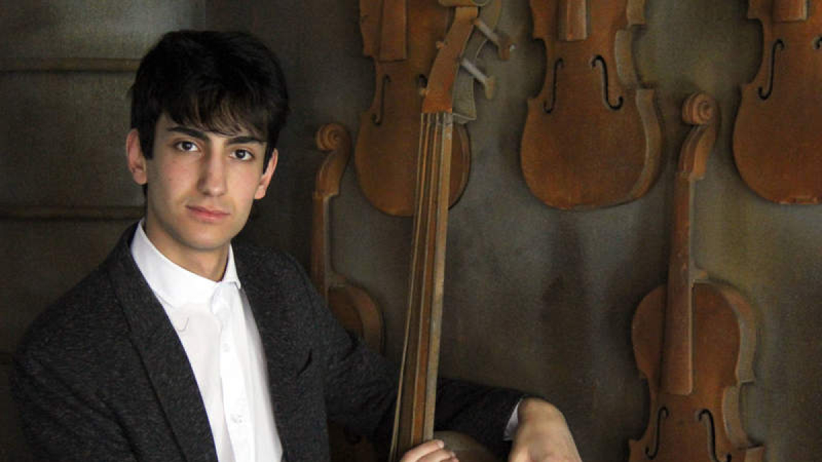Daniel Pacho Villacorta posa ante la escultura de Juan Carlos Uriarte en el conservatorio. DL