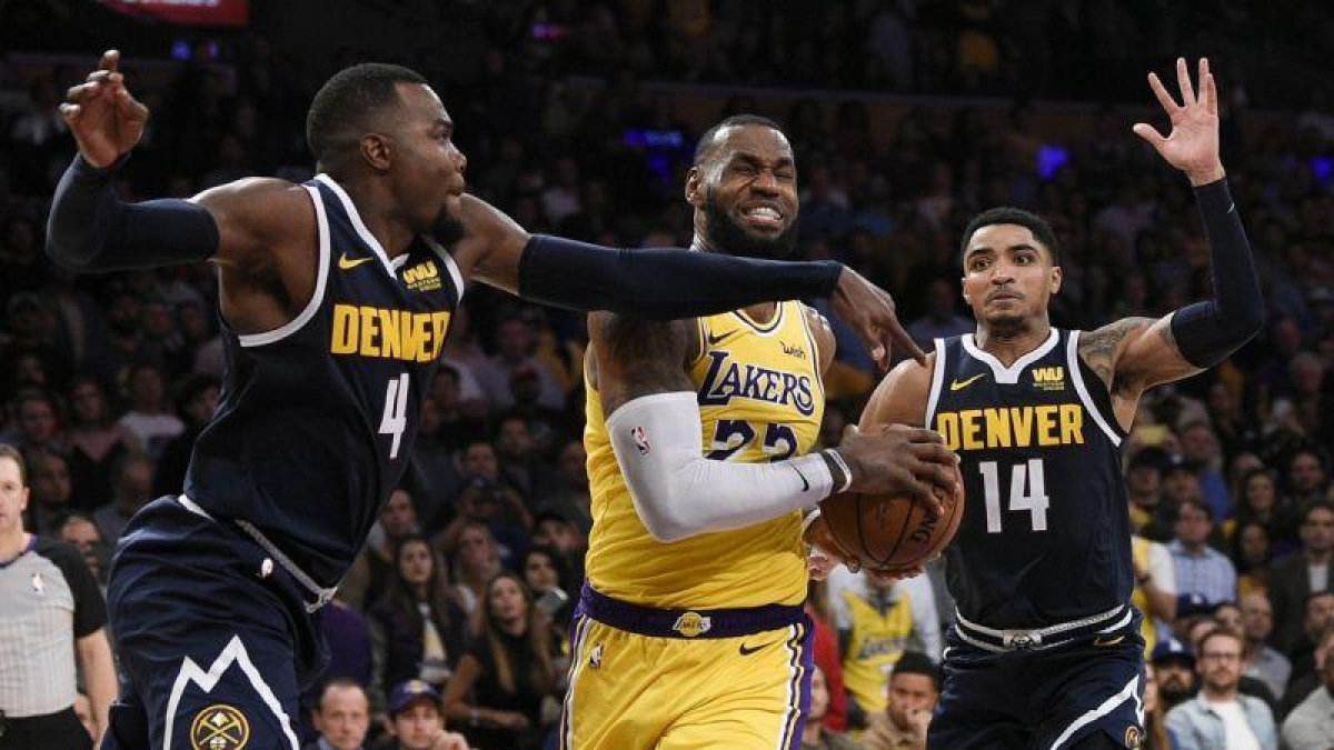 Lebron James protege el balón durante el partido contra los Nuggets de Denver