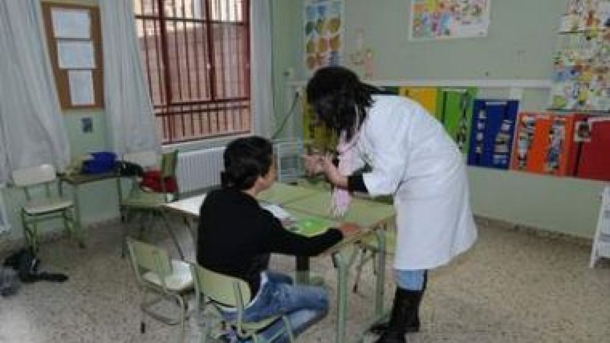 Una profesora de educación especial atiende a un alumno durante la clase.