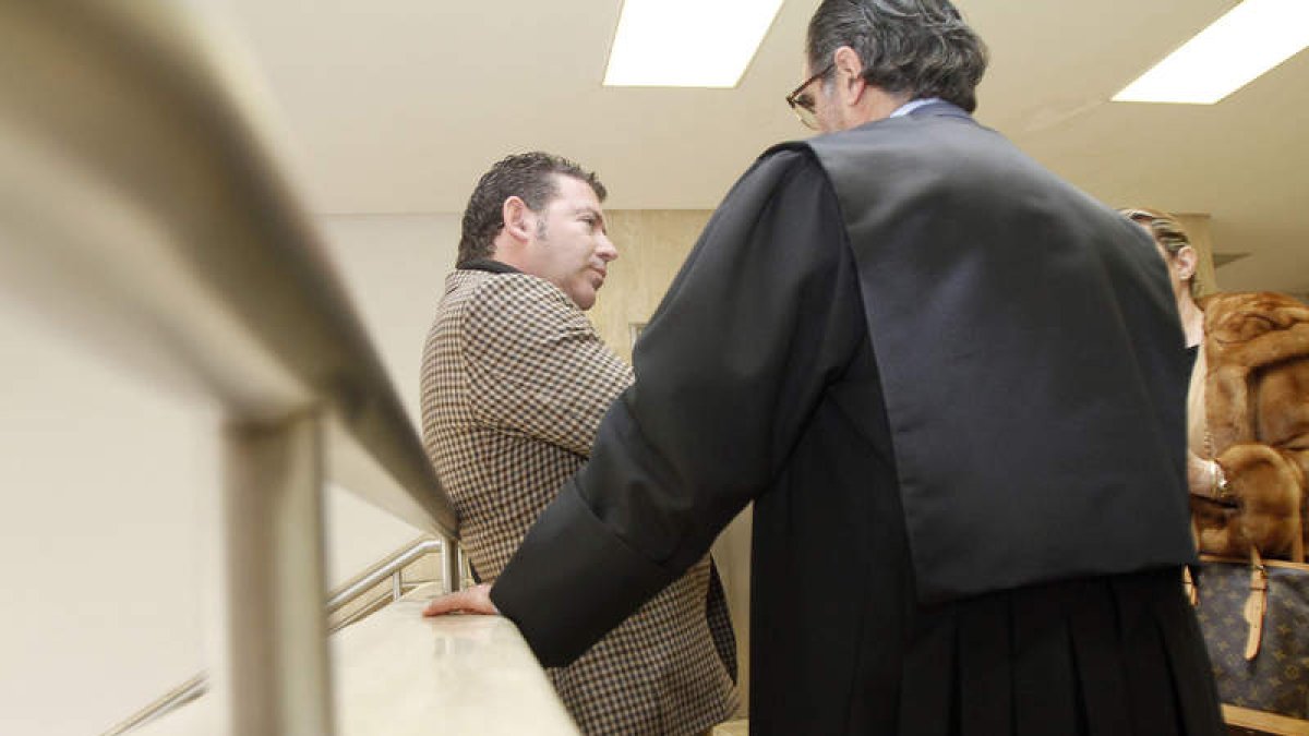 Javier Baena, junto a su abogado, de espaldas, antes de entrar al juicio.