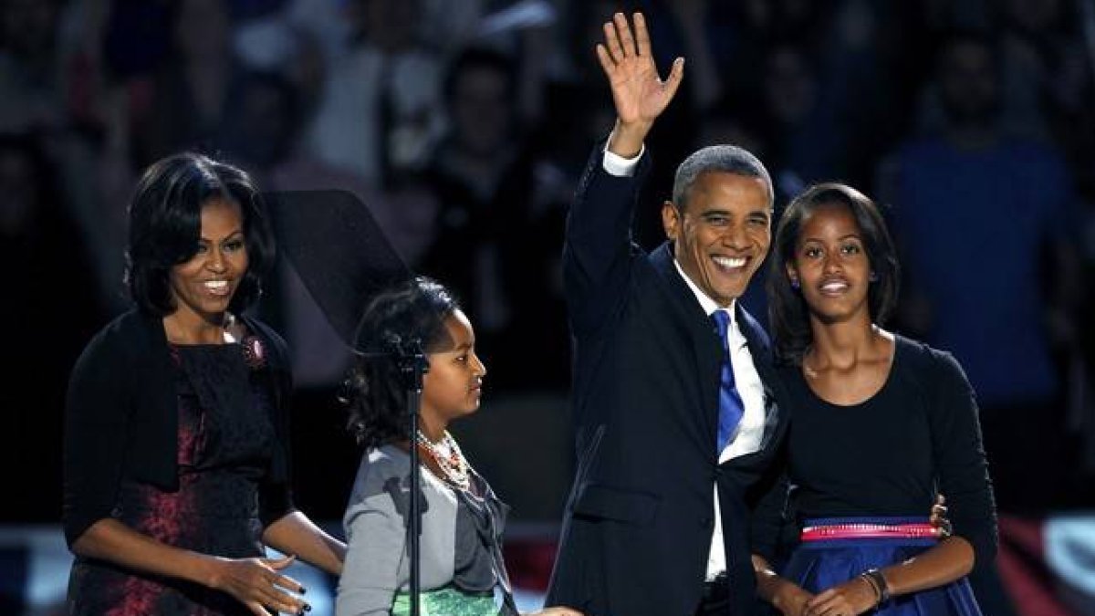 Barack Obama, acompañado de su esposa, Michelle, y de sus hijas Malia (derecha) y Sasha, saluda a sus seguidores, antes de dirigirse a sus seguidores, en Chicago.