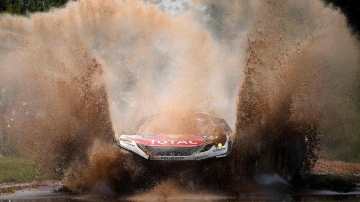 Sebastien Loeb (Peugeot) atraviesa un charco en la etapa de hoy del Dakar.