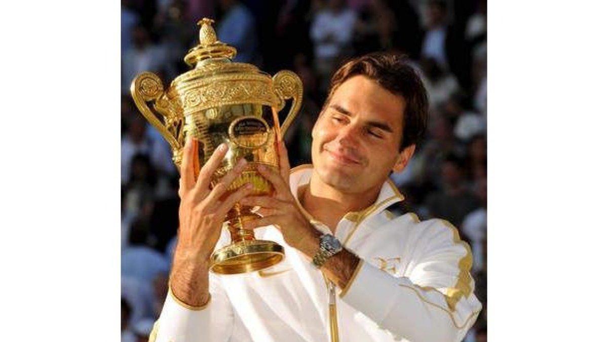 Federer mira la copa con orgullo tras proclamarse por sexta vez campeón de Wimbledon.