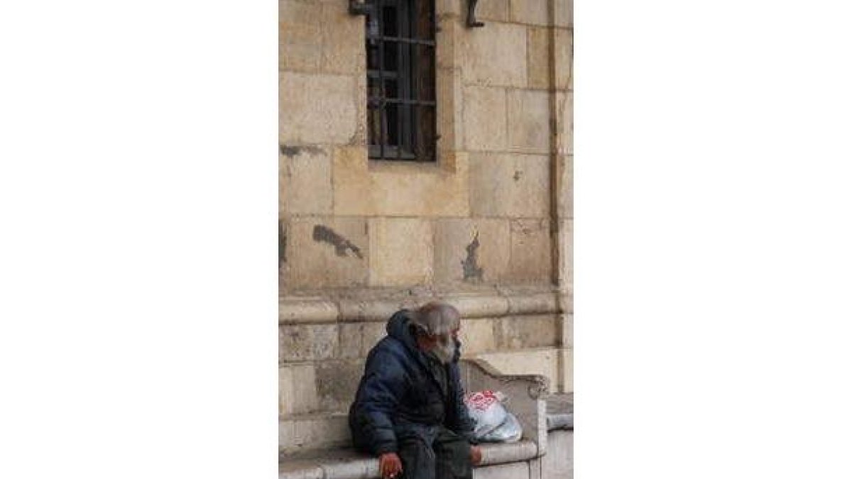 Un sin techo descansa en la plaza Mayor de León.