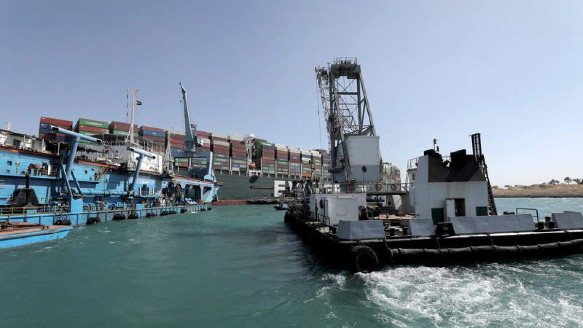 Una remolcadora se dirige al lugar donde ha encallado el gran barco mercante. CANAL DE SUEZ