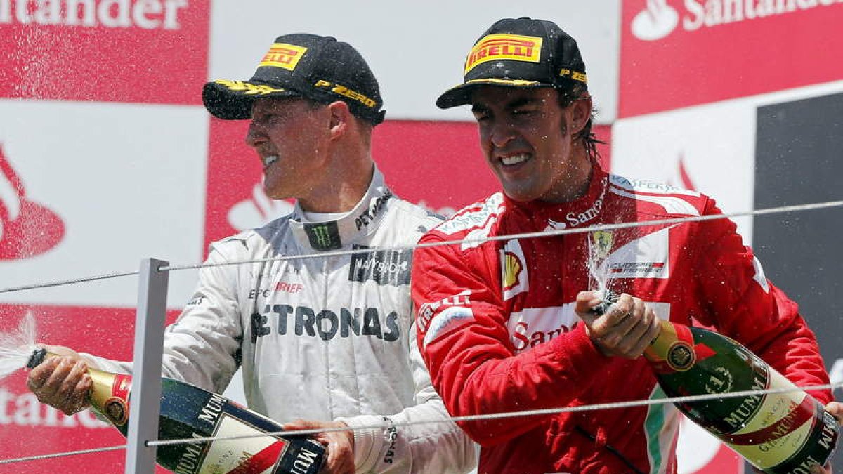 Alonso celebra su victoria junto a Shumacher, tercero.