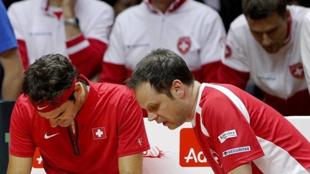 Federer escucha la sinstrucciones del capitán suizo, Severin Luthi, en un descanso de su duelo con Monfils. AP / CHRISTOPHE ENA Federer escucha la sinstrucciones del capitán suizo, Severin Luthi, en un descanso de su duelo con Monfils.