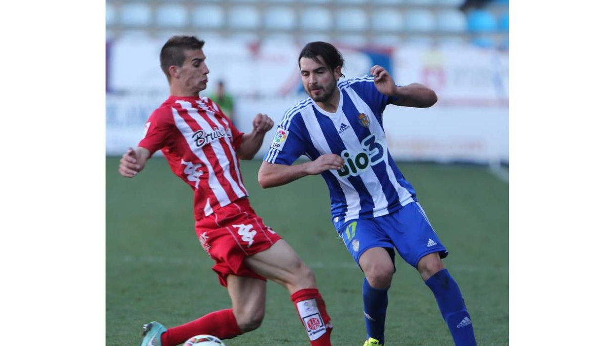 Andy, a la derecha, lucha por el balón frente a un jugador del Girona FC.