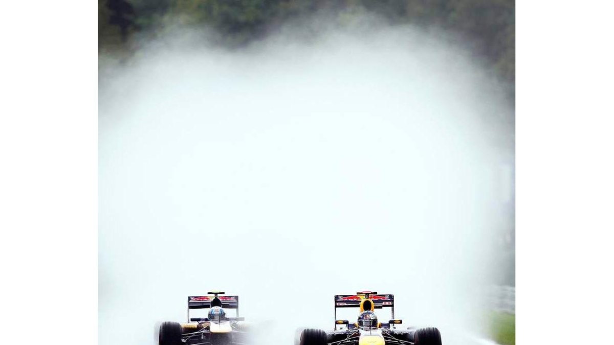 Vettel rueda por delante de Alguersuari bajo la lluvia de Spa.