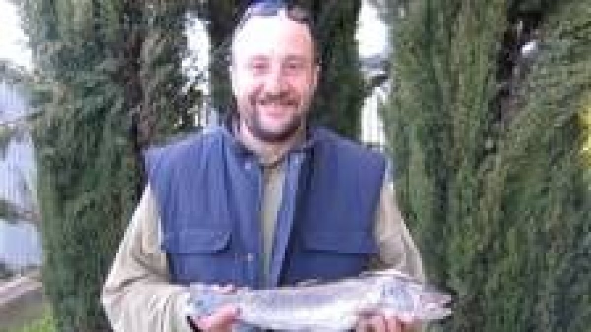 Félix Isaac Fernández posa con su trucha pescada en el Curueño