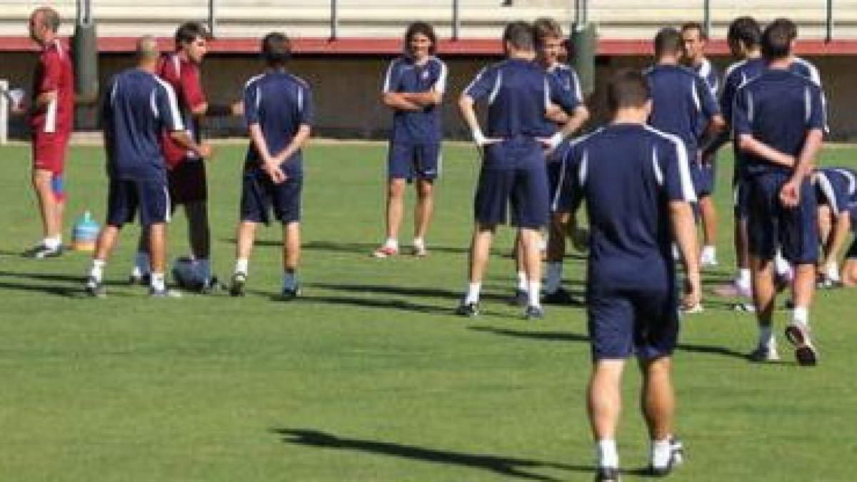 La plantilla de la Cultural realiza unos ejercicios de calentamiento supervisada por el entrenador.