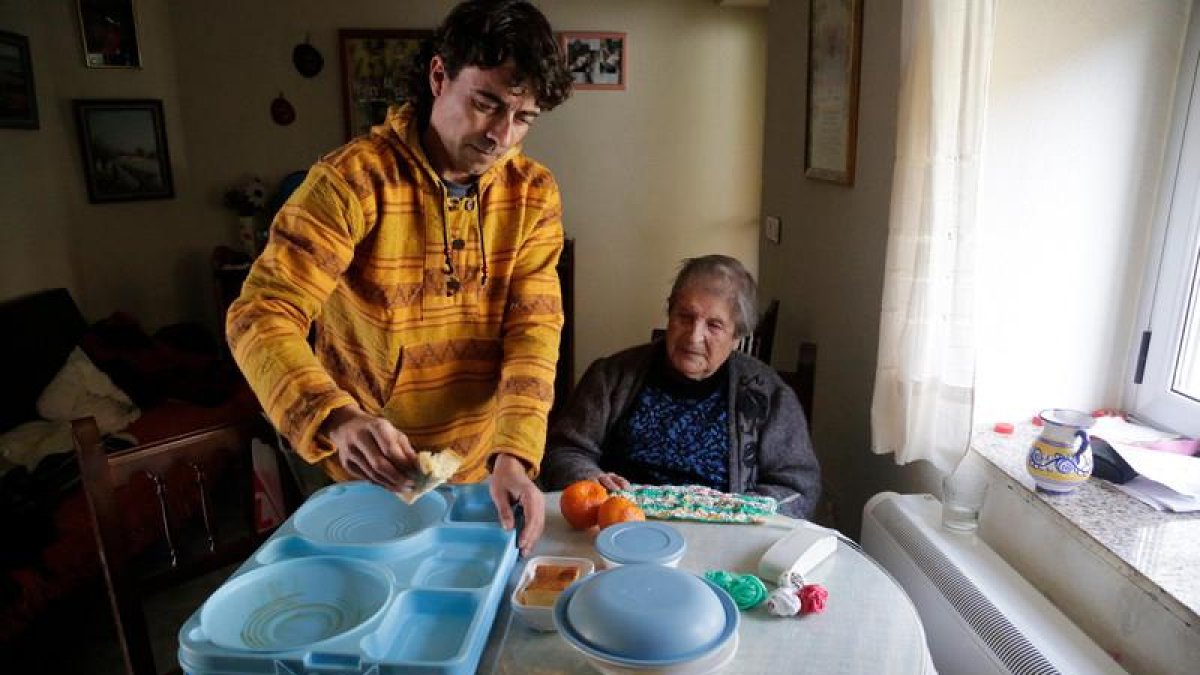 Una vecina de Santas Martas, de 101 años, recibe su menú de manos del trabajador social de Afadeva.