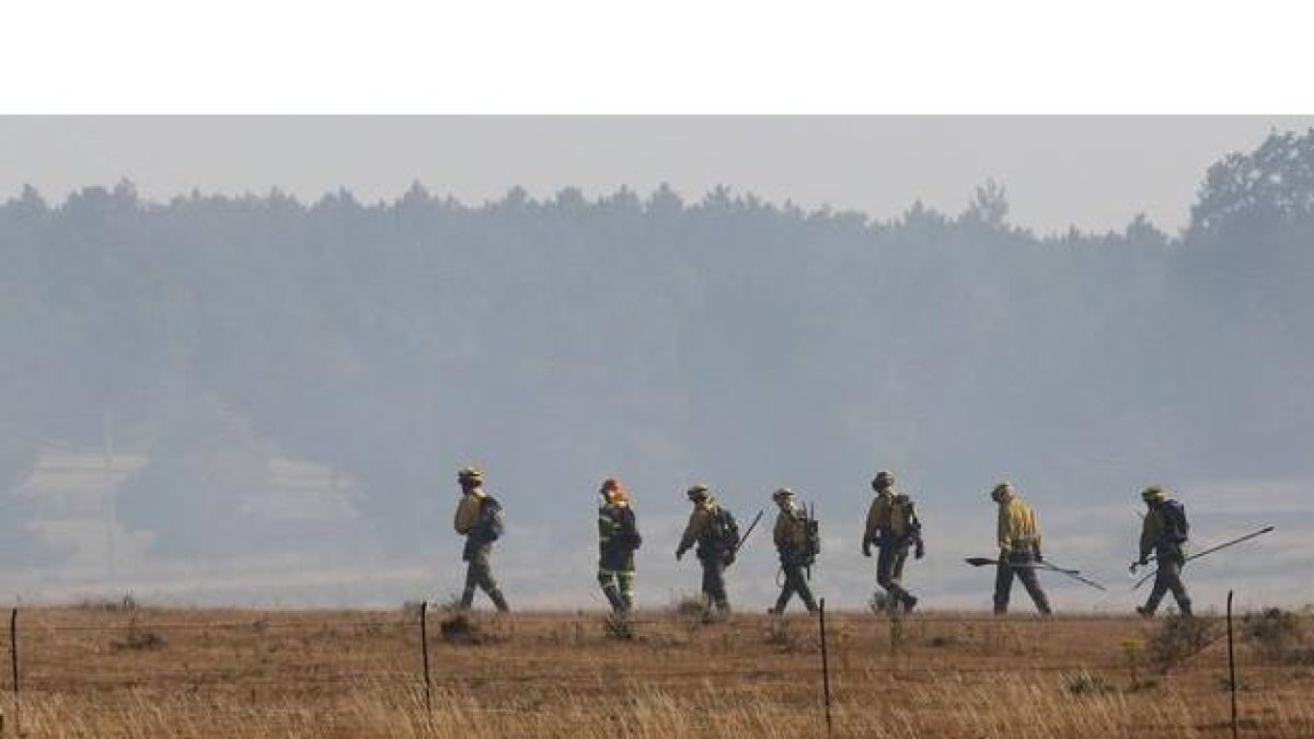 Una brigada contra incendios se dispone a intervenir en un fuego.