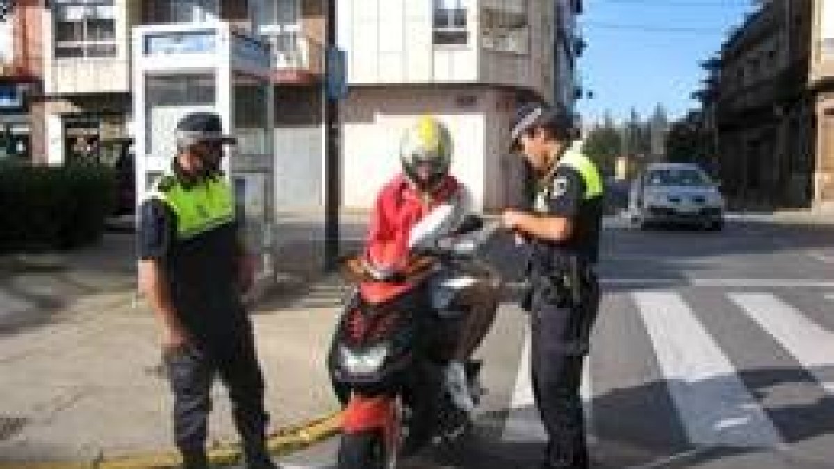 Dos agentes de la policía realizan un control a un motorista, en una imagen de archivo