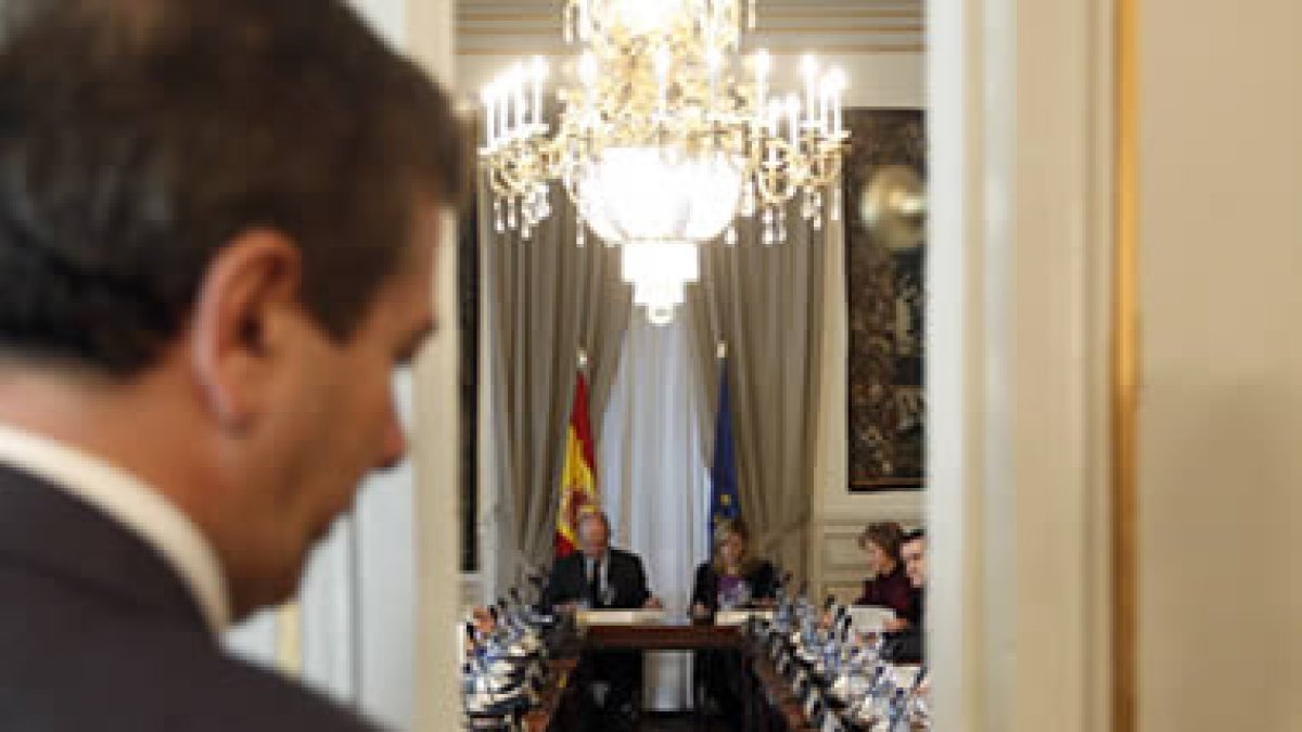 El ujier cierra la puerta para que comience la reunión de la Comisión Mixta.