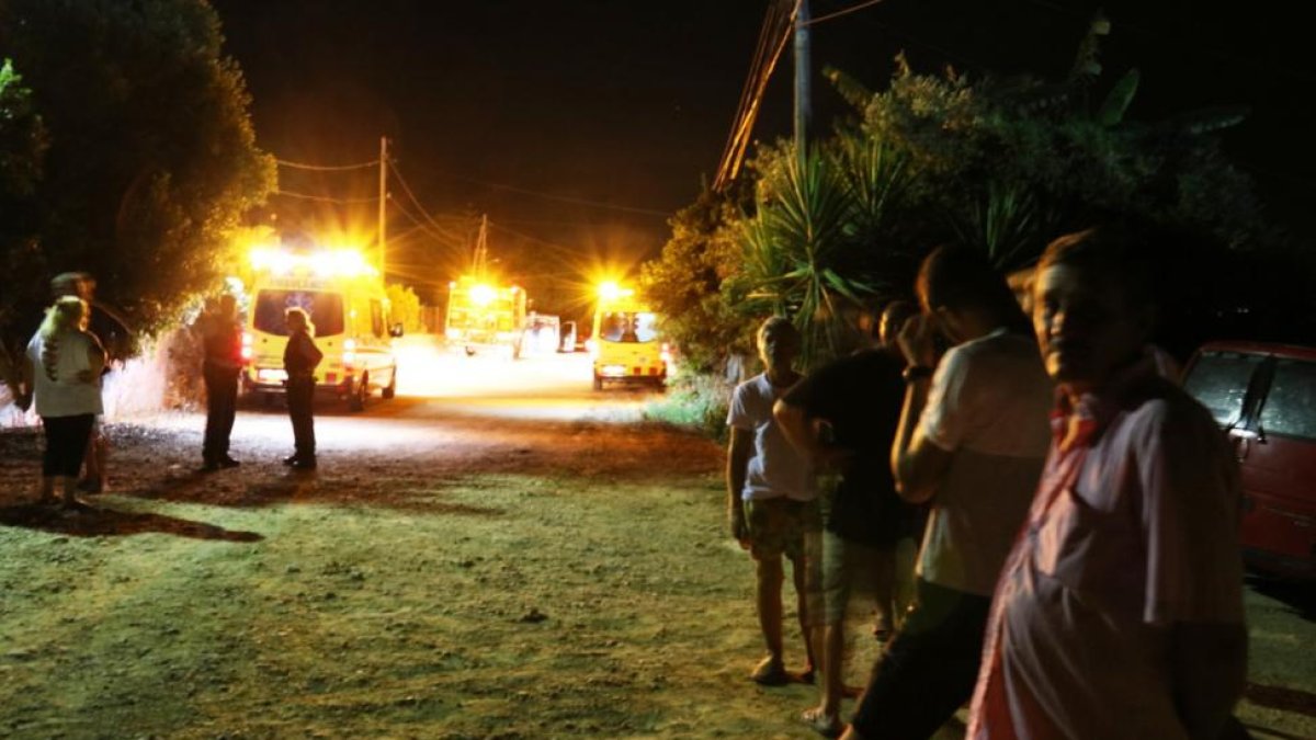 Vecinos y personal de emergencias, en los alrededores de la vivienda siniestrada, en Alcanar