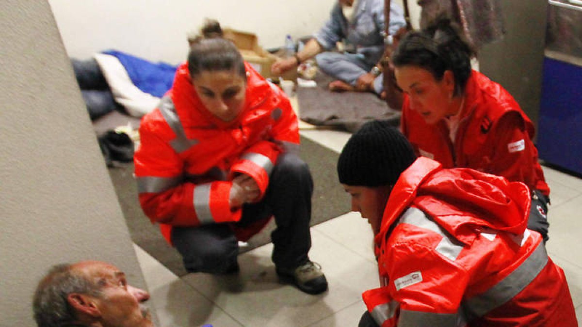 Voluntarios de Cruz Roja junto a personas sin techo.