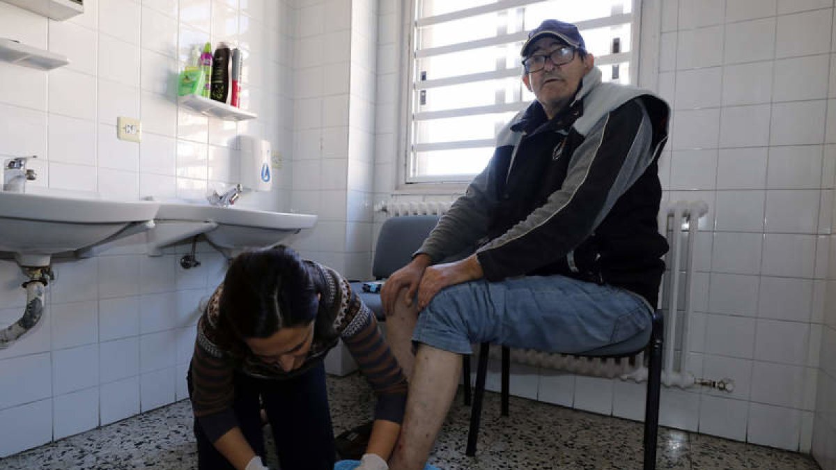 Sefi Herrero, gerente de Calor y Café, corta las uñas a Mario González Pérez. MARCIANO PÉREZ
