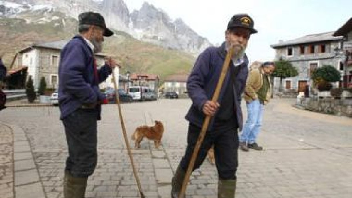 Unos ganaderos de Posada de Valdeón, en la plaza del pueblo.