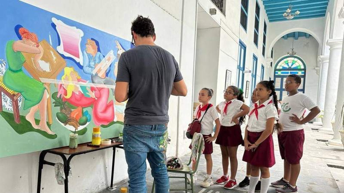 Un grupo de alumnos observa al artista Carlos Álvarez Las Heras mientras pintaba el mural. DL