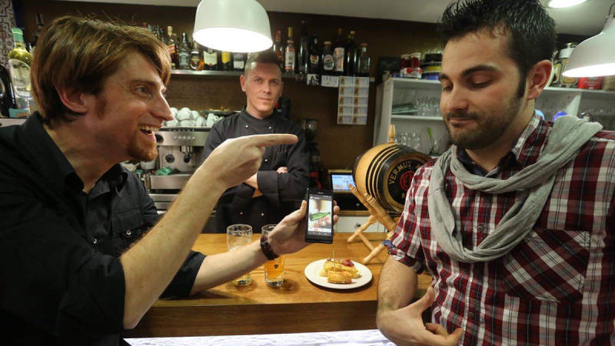 Francisco García Lamela y Yezrael Pérez Fernández juegan en la barra del Rúa 11 con la APP que han ideado, It’s On you, para pagar una ronda.