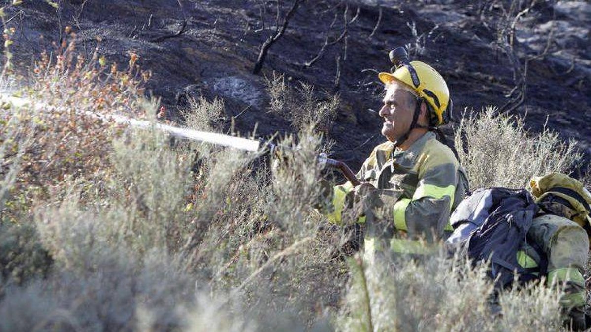 Un bombero trata de luchar contra las últimas llamas del incendio.